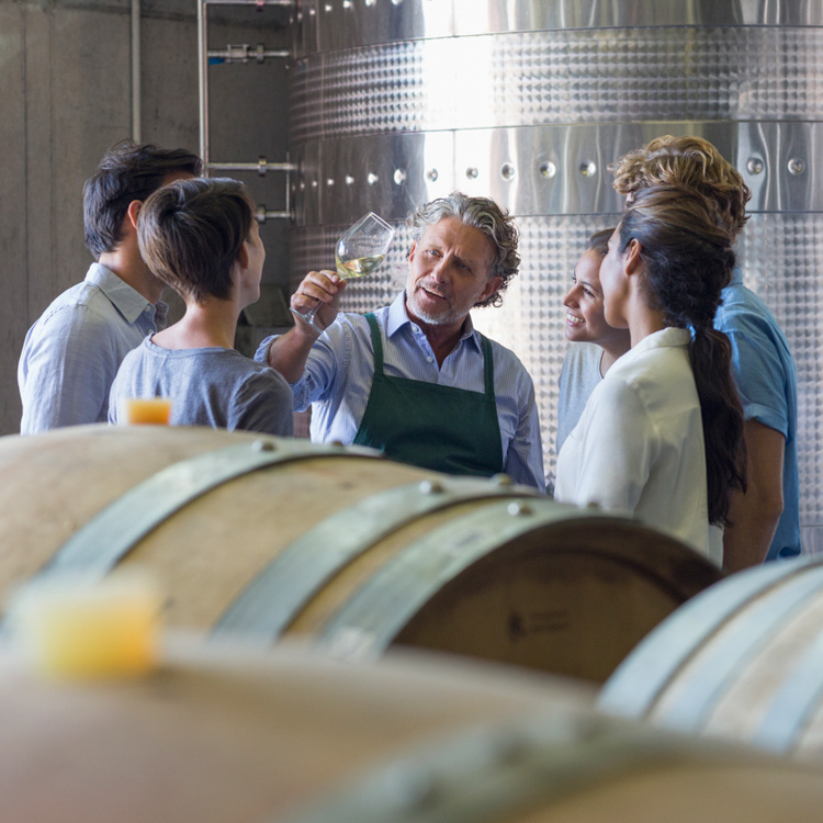 Small business winery worker giving customers a tour