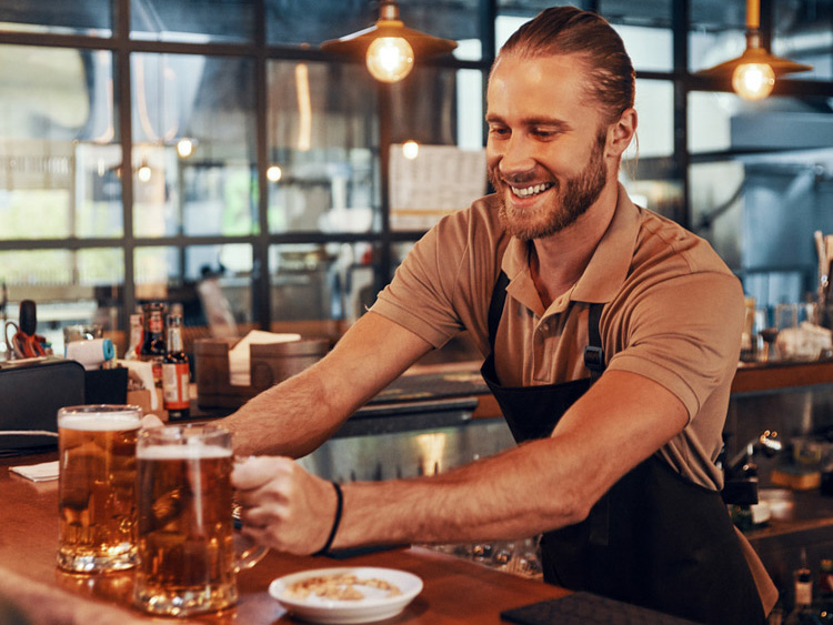Worker serving drinks at local restaurant in Kingston